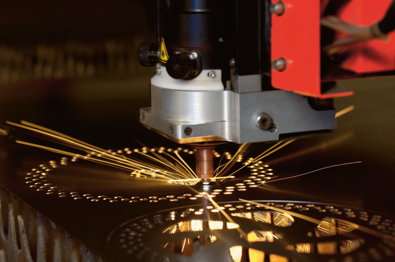 Industrial laser cutting sheet metal, with the beam tracing a kerf through the plate