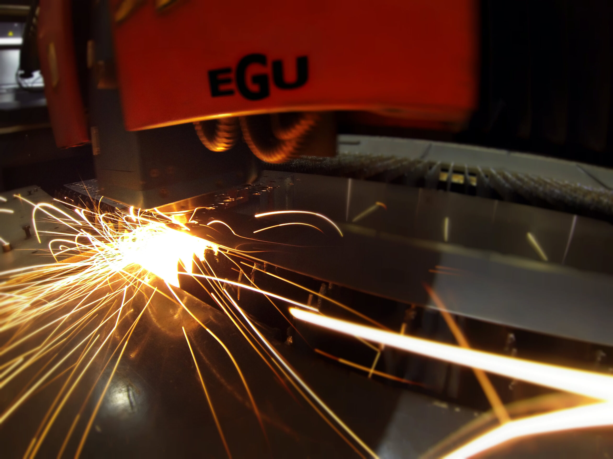 Industrial CO2 laser cutting a 2 mm stainless-steel sheet, with the beam removing a slot in the plate
