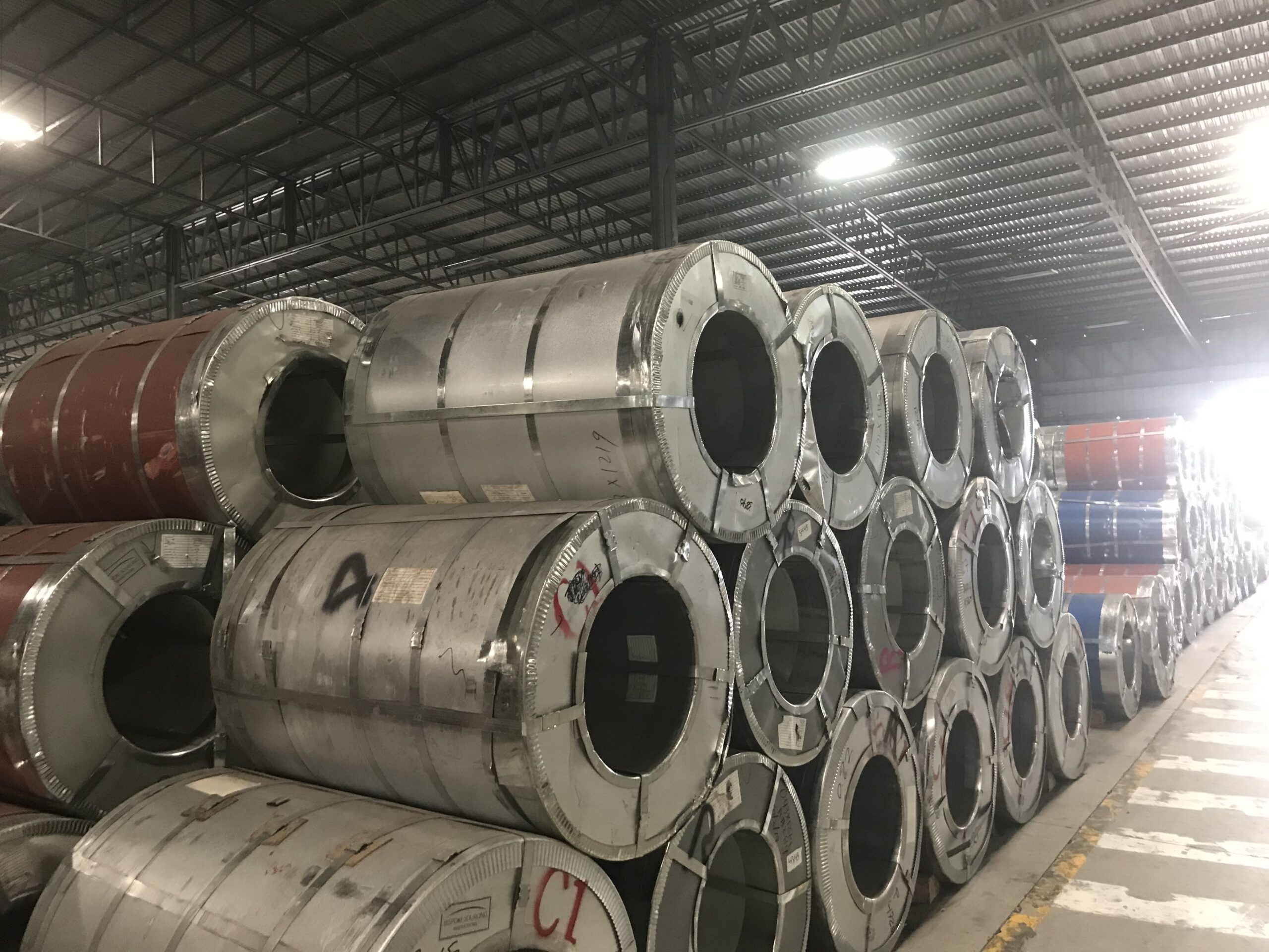Several steel coils standing on end in a warehouse
